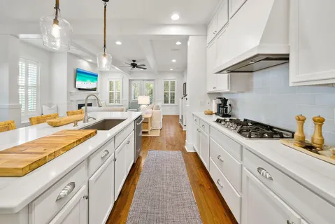 a large kitchen with stainless steel appliances granite countertop a lot of counter space and wooden floors