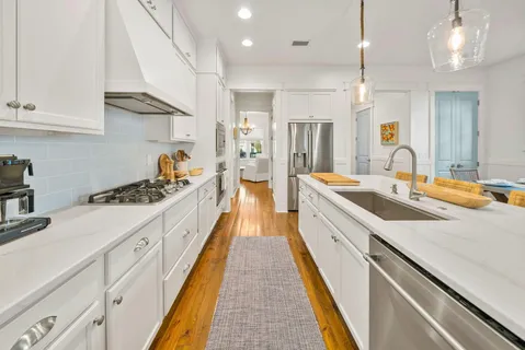 a large kitchen with kitchen island a large counter space a sink appliances and cabinets