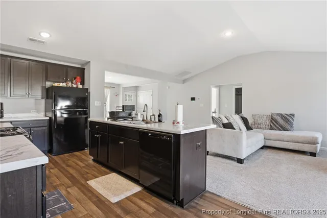 a large living room with stainless steel appliances granite countertop a couch and a counter top space