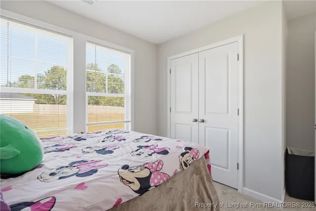 a bedroom with a bed a baby bed and a dresser in it