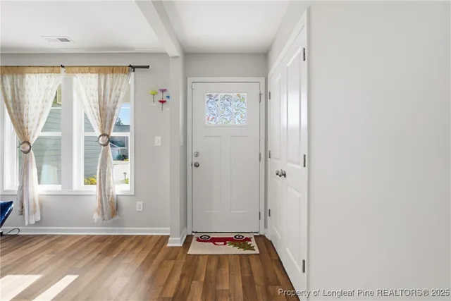 a view of a hallway with wooden floor and windows