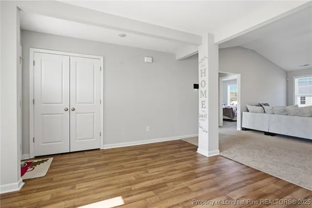 a view of a room with wooden floor and white walls