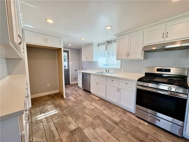 a kitchen with stainless steel appliances granite countertop a stove a sink and a refrigerator