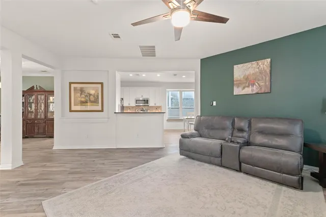 a view of a livingroom with a flat screen tv wooden floor and staircase