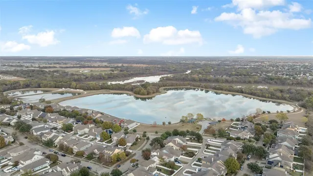 an aerial view of lake and residential houses with outdoor space