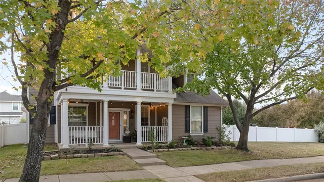 a front view of a house with a tree