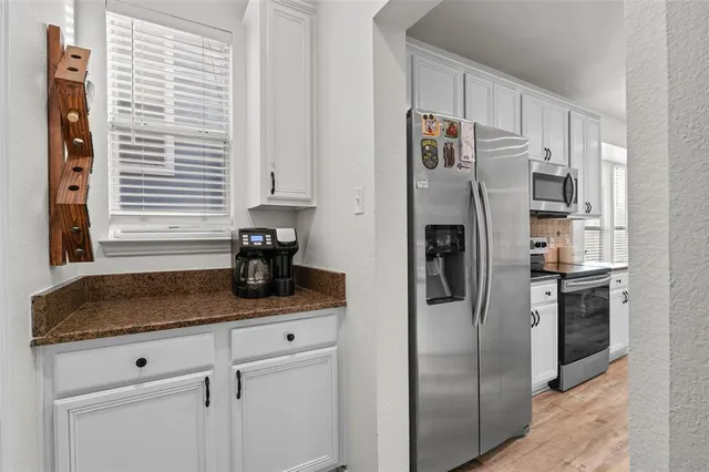 a kitchen with stainless steel appliances granite countertop a refrigerator and a sink