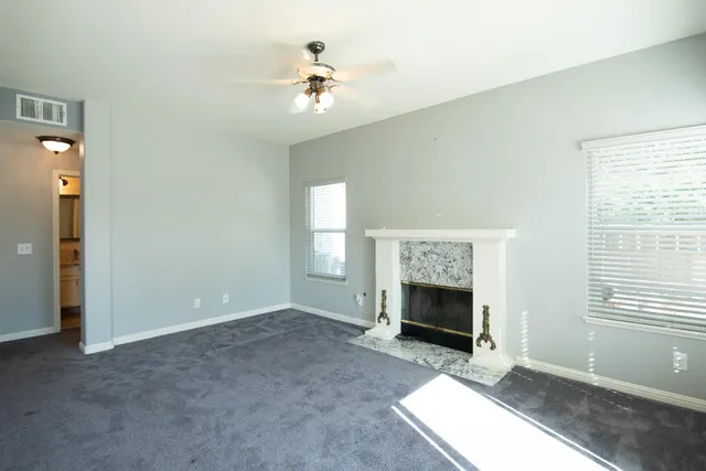 an empty room with fireplace and windows