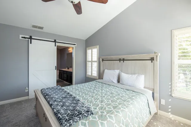 a bedroom with a large bed and a chandelier