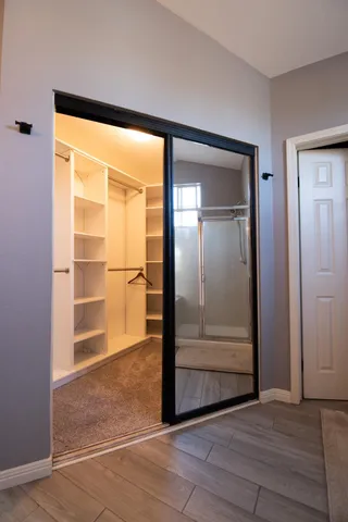 a view of an empty room with cabinet and door