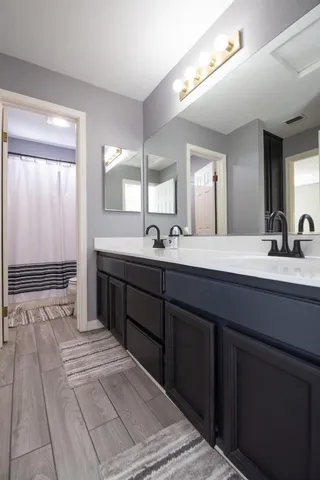 a bathroom with a double vanity sink and a mirror