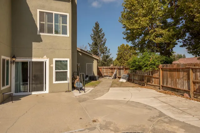 a view of a house with backyard porch and wooden fence