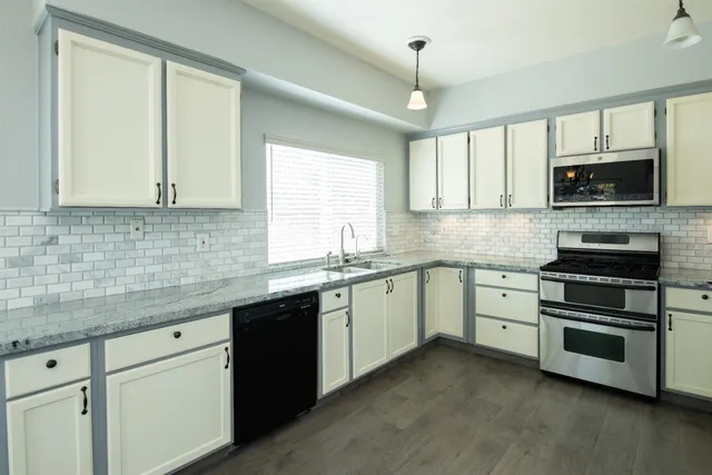a kitchen with stainless steel appliances granite countertop a stove sink microwave and cabinets