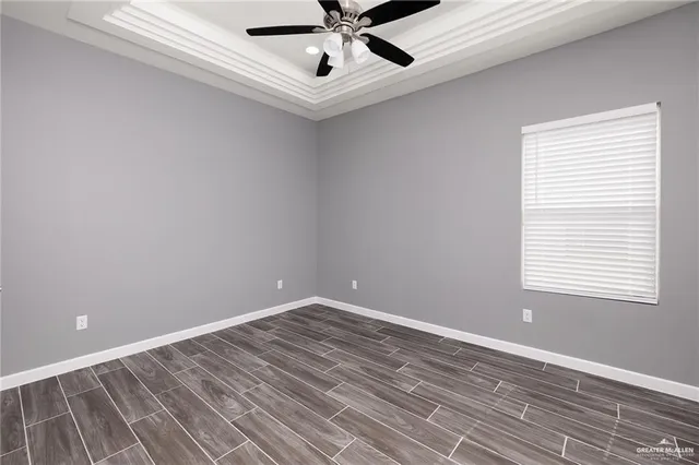 a view of a room with a ceiling fan and wooden floor