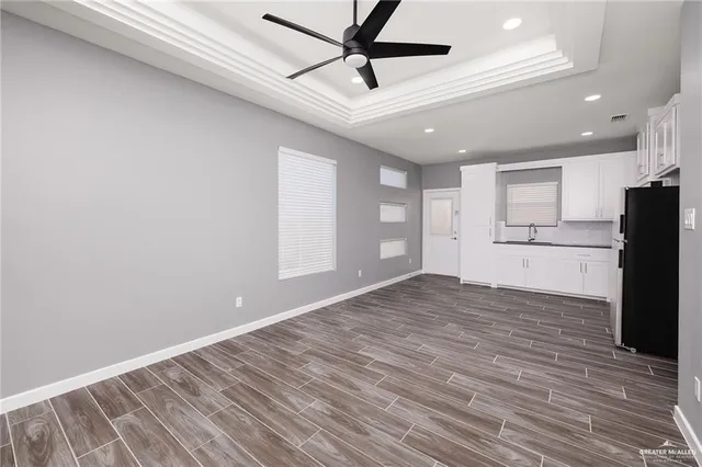 a view of empty room with wooden floor and window