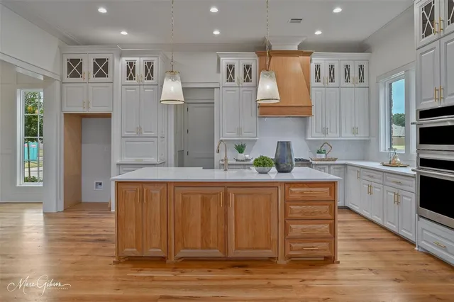 a kitchen with stainless steel appliances granite countertop a sink a stove and cabinets