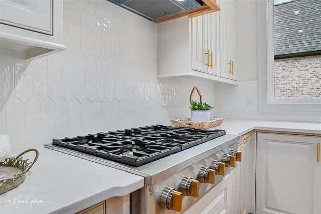 a kitchen with white cabinets and sink