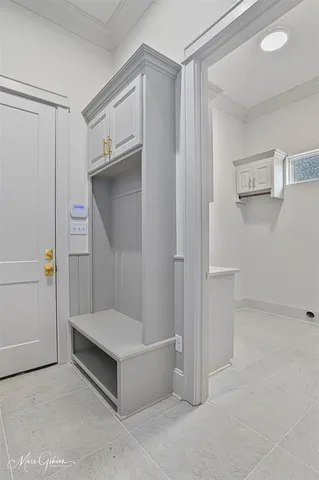 a hallway with white cabinets and wooden floor