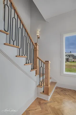 a view of kitchen and an empty room with wooden floor