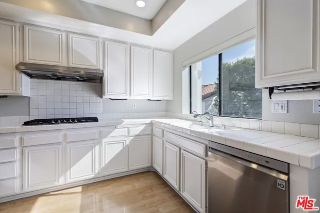 a kitchen with stainless steel appliances granite countertop a sink stove and cabinets