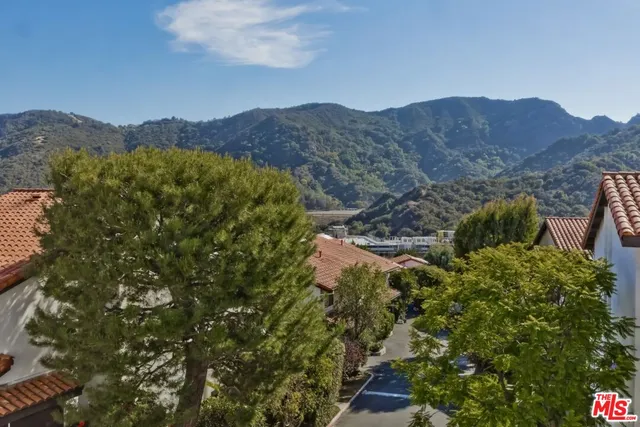 a view of a house with a mountain and a forest