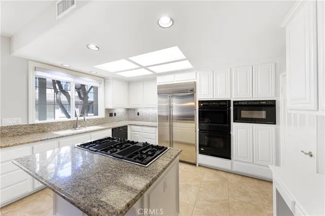 a kitchen with stainless steel appliances granite countertop a stove and a refrigerator