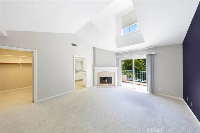 a view of an empty room with a fireplace and a window