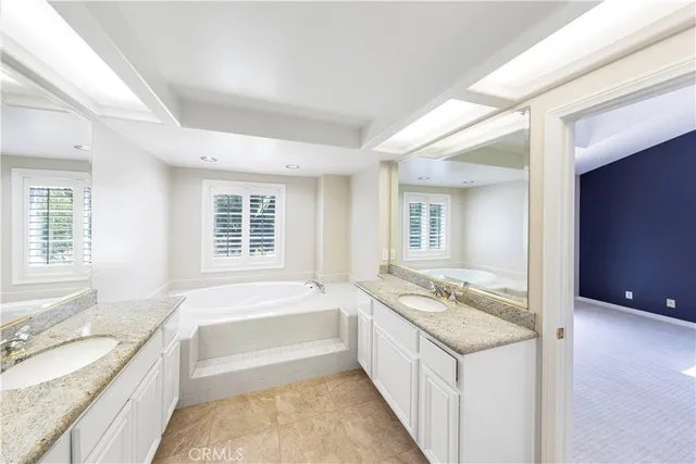 a spacious bathroom with a granite countertop tub sink and mirror
