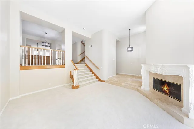 a view of an empty room with stairs and a fireplace
