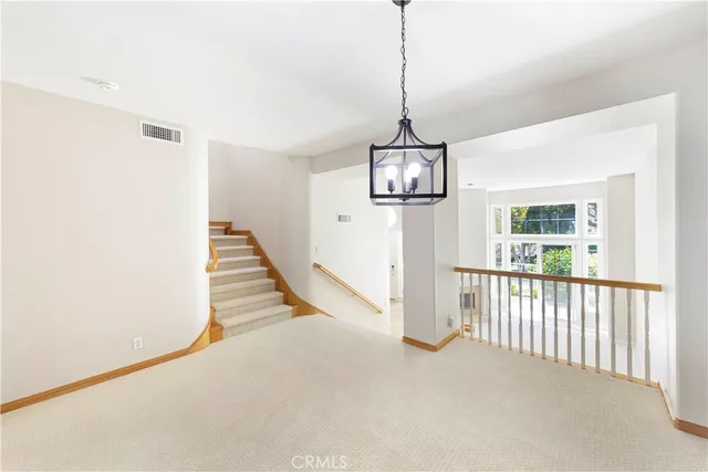 a view of a room with stairs and chandelier