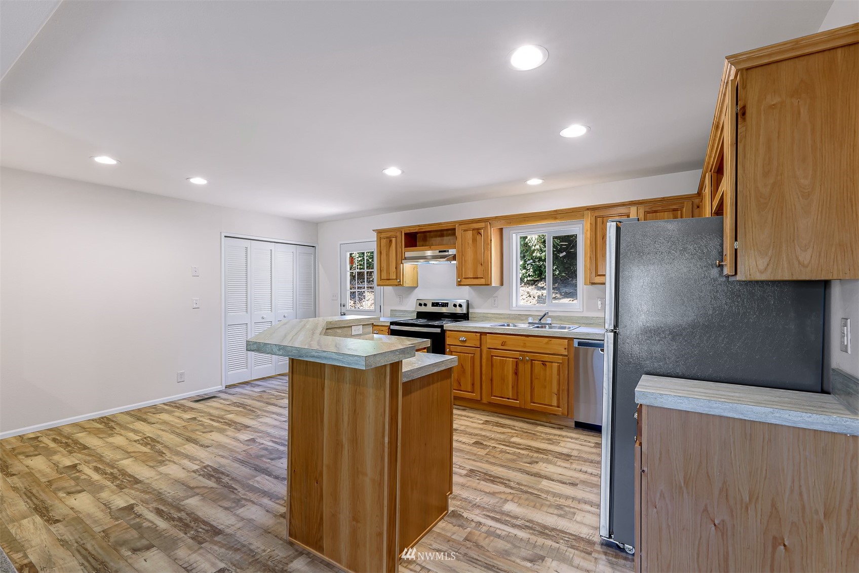 3616 North Red River Road Ferndale, WA 98248 - Photo 7 of 28 a kitchen with kitchen island granite countertop a sink cabinets and wooden floor