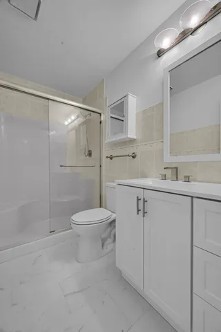 a view of a hallway with a glass door and shower