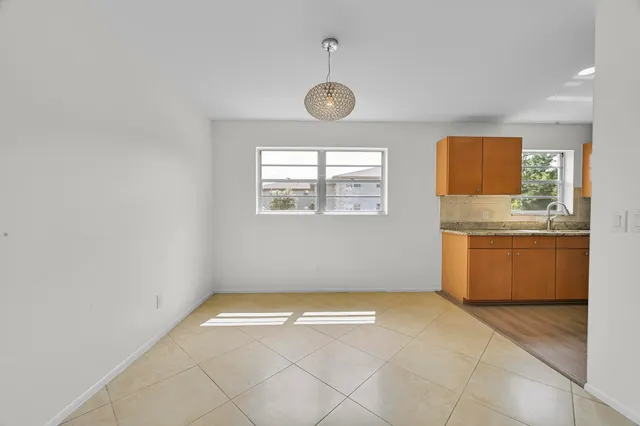 a kitchen with stainless steel appliances granite countertop a sink a stove top oven a refrigerator with wooden cabinets and floor