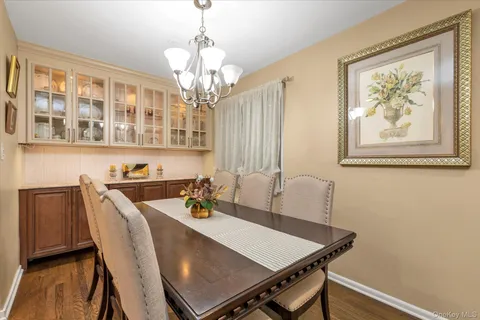 a view of a dining room with furniture a chandelier and wooden floor