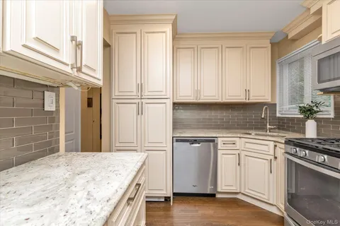 a kitchen with granite countertop cabinets stainless steel appliances and a counter space
