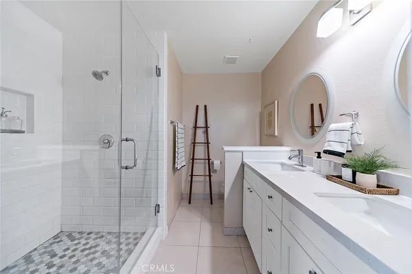 a bathroom with a double vanity sink a shower and a mirror