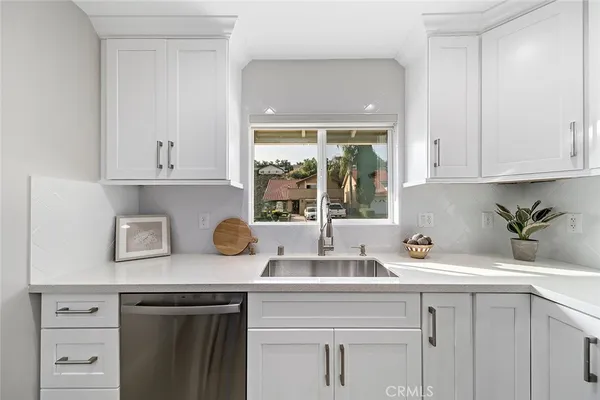 a kitchen with white cabinets and a sink