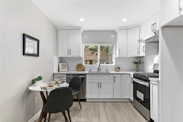 a kitchen with a sink stove and white cabinets