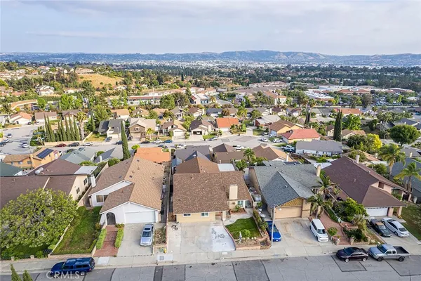 an aerial view of residential houses with outdoor space and trees