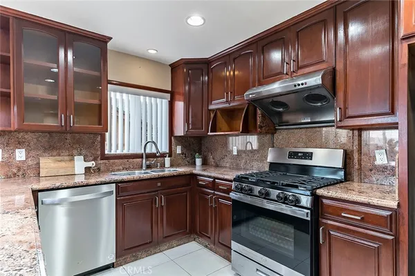 a kitchen with stainless steel appliances granite countertop a sink stove and cabinets