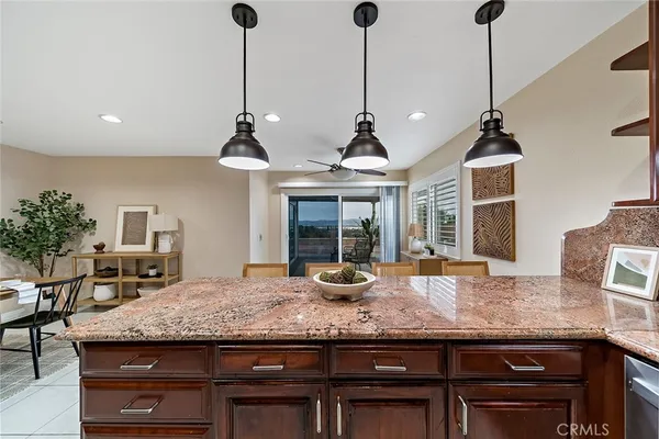 a kitchen with granite countertop kitchen island stainless steel appliances and wooden floor