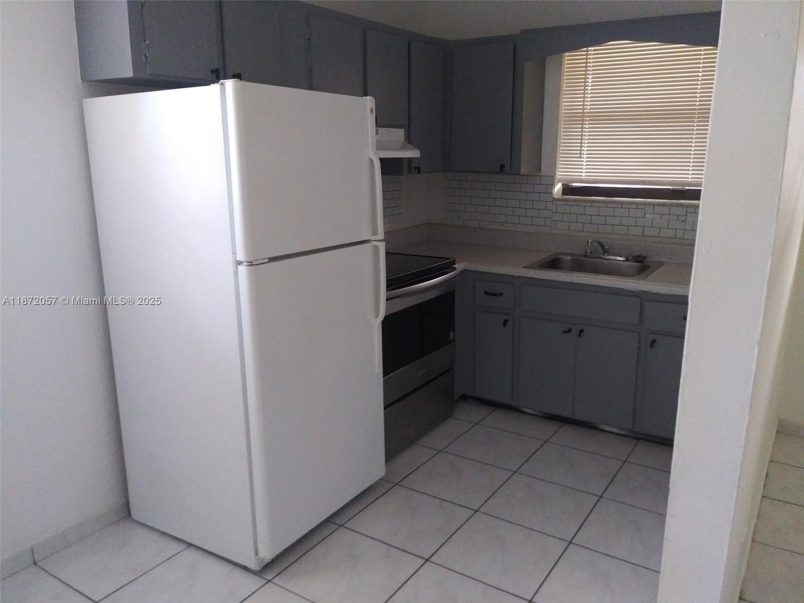 6147 Arthur Street, Unit 1 Hollywood, FL 33024 - Photo 2 of 4 a white refrigerator freezer sitting inside of a kitchen