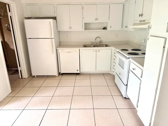 a kitchen with a sink a refrigerator a stove a microwave and cabinets