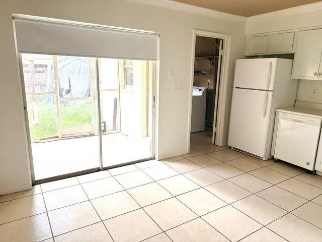 a view of a room that has a large window and a refrigerator