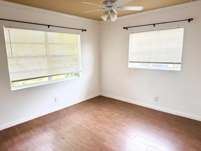 an empty room with a window and a ceiling fan