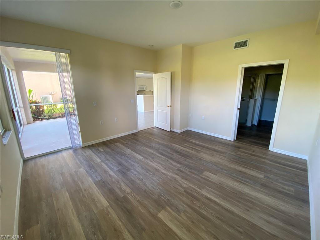 1993 Crestview Way, Unit 129 Naples, FL 34119 - Photo 15 of 26 a view of an empty room with wooden floor and a window