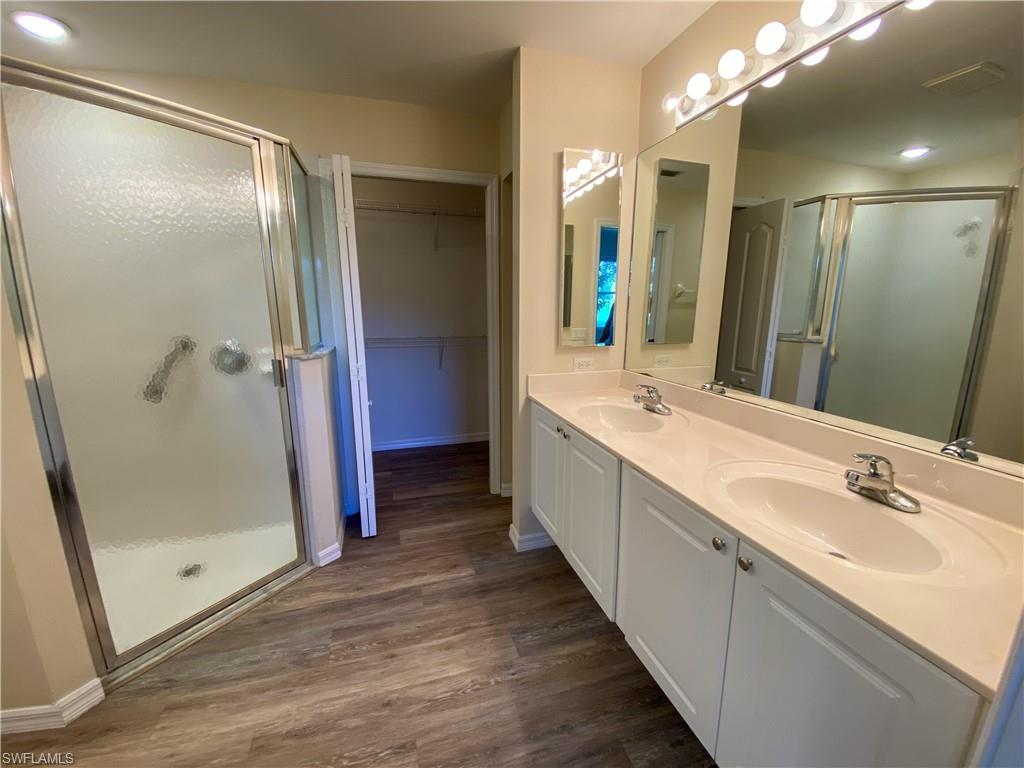 1993 Crestview Way, Unit 129 Naples, FL 34119 - Photo 17 of 26 a bathroom with a double vanity sink and a mirror