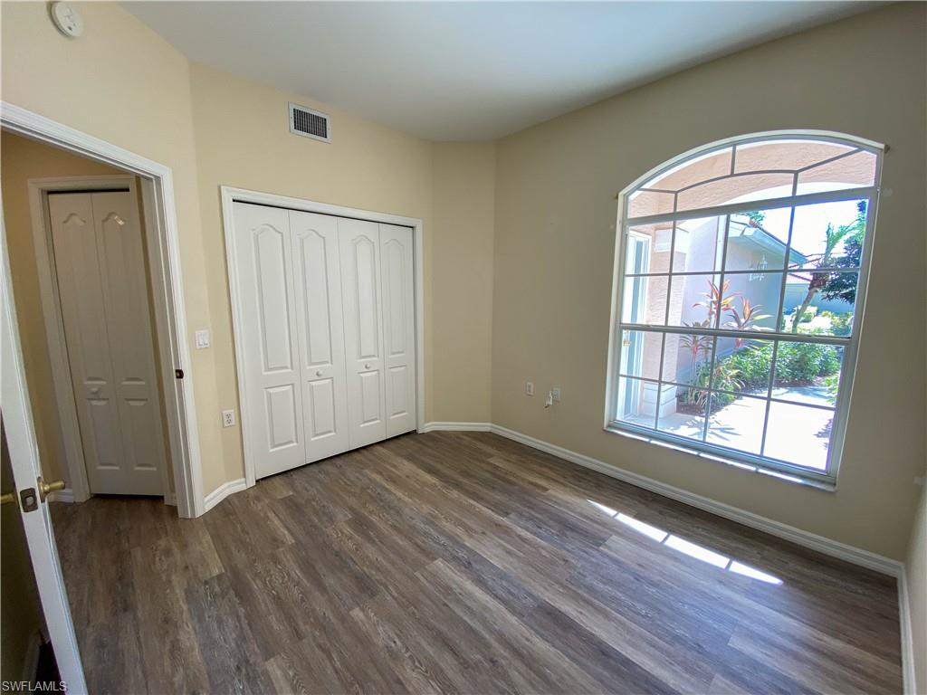 1993 Crestview Way, Unit 129 Naples, FL 34119 - Photo 19 of 26 an empty room with wooden floor and windows
