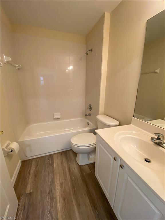 1993 Crestview Way, Unit 129 Naples, FL 34119 - Photo 20 of 26 a bathroom with a granite countertop sink toilet a mirror and bathtub