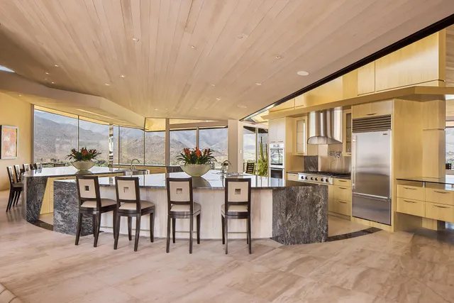 a dining hall with stainless steel appliances a dining table and chairs